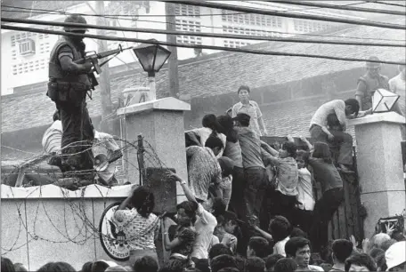  ?? Neal Ulevich Associated Press ?? A CROWD CLIMBS a wall of the U.S. Embassy in Saigon just before the end of the Vietnam War on April 29, 1975. More than a generation ago, the conflict sparked a historic protest movement and a cascade of political shifts, affecting even American films, TV and music.