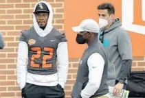  ?? MATTHEW HINTON/AP ?? Alabama’s Najee Harris walks the sideline next to National Team and Dolphins coach Brian Flores during the Senior Bowl on Jan. 30 in Mobile, Ala.