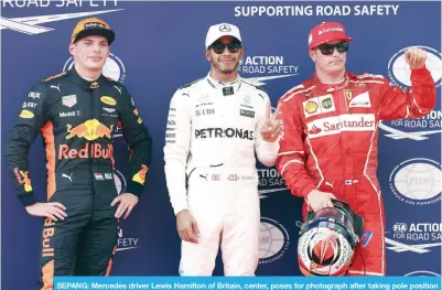  ??  ?? SEPANG: Mercedes driver Lewis Hamilton of Britain, center, poses for photograph after taking pole position after the qualifying round for the Malaysian Formula One Grand Prix in Sepang, Malaysia, yesterday. —AP