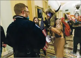  ?? MANUEL BALCE CENETA — THE ASSOCIATED PRESS ?? Supporters of President Donald Trump are confronted by U.S. Capitol Police officers inside the Capitol. An Arizona man seen in photos and video of the mob wearing a fur hat with horns was charged Saturday in Wednesday’s chaos. Jacob Anthony Chansley, who also goes by the name Jake Angeli, was taken into custody Saturday.