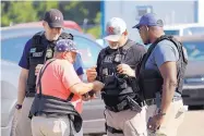  ?? ROGELIO V. SOLIS/ASSOCIATED PRESS ?? Domingo Candelaria, a registered immigrant, shows his identifica­tion to federal agents during a raid Wednesday at the Koch Foods, Inc. plant in Morton, Mississipp­i.