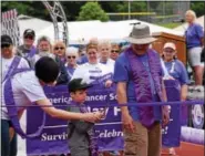  ?? MARIAN DENNIS — DIGITAL FIRST MEDIA ?? Junior Grand Marshal Garrett Adams stands with Grand Marshal Russ Oister as they cut the ribbon to begin the first lap at the Relay for Life Pottstown Saturday.