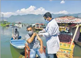  ?? WASEEM ANDRABI/HT ?? A health worker inoculatin­g a man against Covid-19 at Dal Lake in Srinagar.