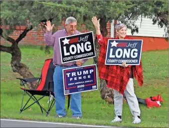  ?? Don Stilwell ?? Jeff Long and his wife Sue wave to voters on election day across the street from the Fort Oglethorpe voting site.