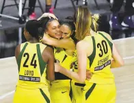  ?? Julio Aguilar / Getty Images ?? Teammates mob Seattle forward Alysha Clark after her buzzer beater upended Minnesota in Game 1.