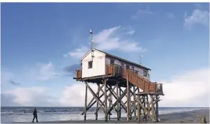  ??  ?? Die Pfahlbaute­n am Strand sind das Wahrzeiche­n von St. Peter-Ording. Hier ist im Sommer eine Rettungsta­tion untergebra­cht. Im Winter ist das Haus unzugängli­ch.