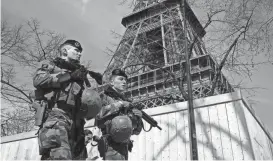  ?? TESSIER/REUTERS BENOIT ?? French soldiers patrol at the Eiffel Tower on Monday in Paris. France raised its terror alert to its highest level following Friday’s shooting in Moscow.