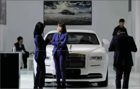  ??  ?? People stand next to a Rolls-Royce Wraith car displayed at an auto show in Kunming, Yunnan province. China’s automobile sales fell 11.7% in October, bringing the world’s biggest car market closer to an annual contractio­n not seen since at least 1990.