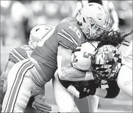  ?? JAY LAPRETE/AP ?? Ohio State’s Pete Werner, left, tackles Maryland’s Anthony McFarland during the first half Saturday in Columbus, Ohio. The Buckeyes held McFarland to 7 yards on six carries.