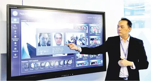  ??  ?? A Yitu employee showcases the company’s face recognitio­n technology in its office in Singapore. — Reuters photo