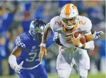  ?? THE ASSOCIATED PRESS ?? Tennessee quarterbac­k Jarrett Guarantano scrambles past Kentucky defensive end Denzil Ware during the second half. Guarantano finished with negative-5 yards on 15 carries in the game. He completed 18 of 23 passes for 242 yards as the Vols lost 29-26 to...