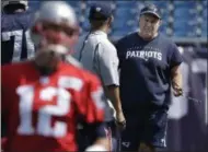  ?? STEVEN SENNE — THE ASSOCIATED PRESS ?? New England Patriots head coach Bill Belichick, right, walks on the field as quarterbac­k Tom Brady (12) warms up during an NFL football practice, Tuesday in Foxborough, Mass.