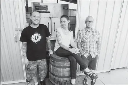  ?? Bill Wade/post-gazette ?? In front of the big smoker at Union Pig & Chicken in East Liberty are, from left, chef Mike Lefever, general manager Jessicarob­yn Keyser and owner Kevin Sousa. Below: The narrow dining room with sleek communal tables.