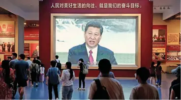  ?? (AFP) ?? People walk past a screen showing Chinese President Xi Jinping at the Museum of the Communist Party of China in Beijing on September 4