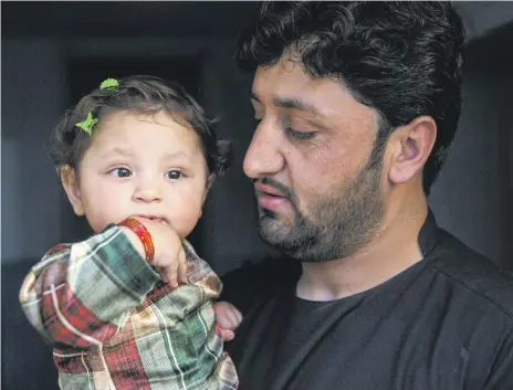  ?? Stefanie Glinski for The National ?? Rafiullah Sharifi with his daughter Amina, who was injured by bullets when ISIS attacked a Kabul maternity hospital last May, killing 24 people. Amina, whose mother died in the attack, has had several surgeries to save her leg