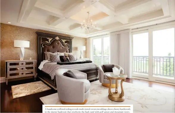  ??  ?? A handsome coffered ceiling reveals multi-tiered crown mouldings above cherry hardwoods in the master bedroom that overlooks the back yard with golf green and mountain views.