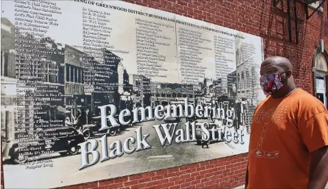  ?? Associated Press ?? ■ Freeman Culver stands in front of a mural Monday listing the names of businesses destroyed during the 1921 Greenwood massacre in Tulsa, Okla.