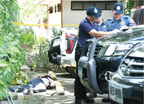  ?? SUNSTAR FOTO / RUEL ROSELLO ?? DEATH IN THE ARCHBISHOP’S PALACE. Police officers go over their notes on the encounter that killed Jefrey Cañedo, a retired policeman’s son, inside the Archbishop’s Palace compound on D. Jakosalem St., Cebu City before noon Tuesday.