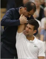  ?? FILE — THE ASSOCIATED PRESS ?? Serbia’s Novak Djokovic as he receives treatment from a trainer during a break in his Men’s Singles Match against Adrian Mannarino of France on day eight at the Wimbledon Tennis Championsh­ips in London. Novak Djokovic will miss the rest of this season...