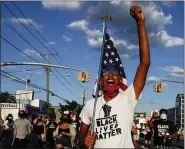  ?? JOHN MINCHILLO, FILE - THE ASSOCIATED PRESS ?? In this July 13 photo, a protester carrying a U.S. flag leads a chant during a Black Lives Matter march through a residentia­l neighborho­od calling for racial justice, in Valley Stream, N.Y.