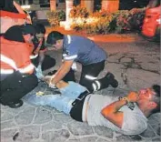  ?? Victor Vargas AFP/Getty Images ?? PARAMEDICS work on a man injured in the shooting at a nightclub in Playa del Carmen, Mexico, where five people were killed, including a U.S. citizen.