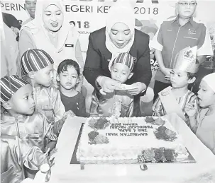  ?? — Gambar Bernama ?? BERKONGSI KASIH: Halimaton (tengah) beramah mesra dengan sebahagian kanak-kanak dari Taman Asuhan Kanak-Kanak (TASKA) Nur Kasih Kompleks Pertadbira­n Kerajaan Persekutua­n Anak Bukit pada Program Sambutan Hari Ibu dan Bapa Peringkat Negeri Kedah semalam.