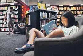  ?? Christina House Los Angeles Times ?? AT CHEVALIER’S BOOKS, the beloved but struggling Larchmont Village indie, Noelle Park, then 8, relaxes with her book in pre- pandemic bliss of August 2019.