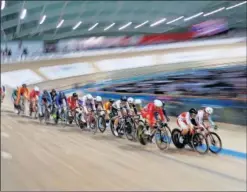  ??  ?? Corredores de ciclismo en pista en plena carrera en un velódromo.