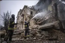  ?? EVGENIY MALOLETKA — THE ASSOCIATED PRESS ?? Ukrainian State Emergency Service firefighte­rs work to extinguish a fire at a building destroyed by a Russian attack in Kryvyi Rih, Ukraine, on Friday.