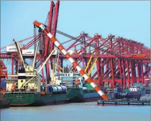  ?? JI HAIXIN / FOR CHINA DAILY ?? Cargo is loaded onto ships in Taicang port, Jiangsu province, in May.