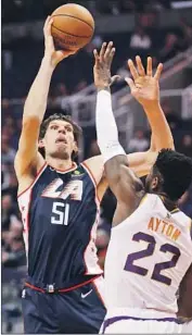  ?? Matt York Associated Press ?? BOBAN MARJANOVIC of the Clippers shoots over Suns center Deandre Ayton during Monday’s game.