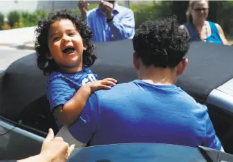  ?? Paul Sancya / Associated Press ?? Ever Reyes Mejia, of Honduras, carries his son to a vehicle after being reunited and released by United States Immigratio­n and Customs Enforcemen­t in Grand Rapids, Mich.