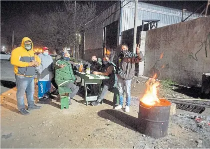  ?? ROLANDO ANDRADE ?? Con frío. Militantes sindicales anoche, en el ingreso de la planta de Química Oeste.