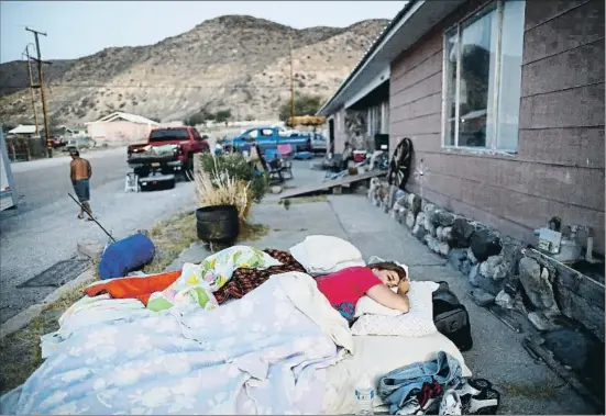  ?? UNA MARIO TAMA / GETTY ?? Una mujer duerme a la puerta de la casa de sus padres, que quedó inhabitabl­e tras el seísmo de magnitud 7,1 en Trona, el 8 de julio