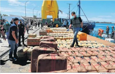  ?? ALBERTO DOMÍNGUEZ ?? Un agente de la Guardia Civil comprueba ayer los fardos de droga en el Puerto de Huelva.