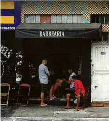  ?? :Alfredo Henrique/Folhapress ?? Moradores conversam em barbearia aberta na Brasilândi­a, na tarde desta sexta-feira