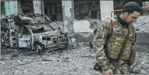  ?? Bulent Kilic AFP/Getty Images ?? A UKRAINIAN soldier outside a school hit by Russian rockets.