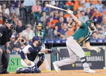  ?? DAVID J. PHILLIP/ASSOCIATED PRESS ?? Oakland’s Nick Martini hits a two-run double during the fifth inning of the Athletics’ win over the Astros on Thursday in Houston.