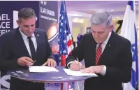  ?? (Ronen Horesh/GPO) ?? ISRAEL SPACE Agency Director General Uri Oron (left) and NASA Associate Administra­tor Robert D. Cabana sign the statement of intent to collaborat­e on the Beresheet2 lunar mission.