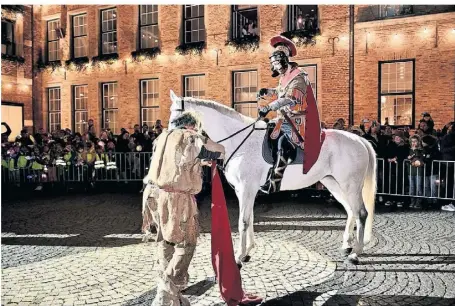  ?? RP-FOTO: WOLFGANG HARSTE ?? Sven Hövelmann auf dem Pferd bei der Mantelteil­ung mit dem Bettler vor dem Rathaus. Für ihn war es eine Premiere als neuer St. Martin beim Umzug in der Altstadt.