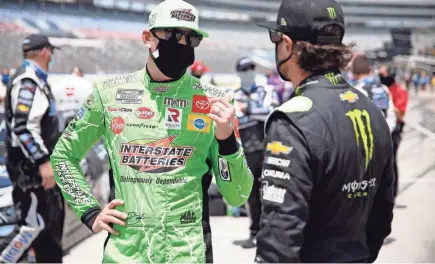  ??  ?? Kyle Busch, left, and Kurt Busch talk on pit road prior to Sunday’s NASCAR Cup Series race at Texas Motor Speedway.