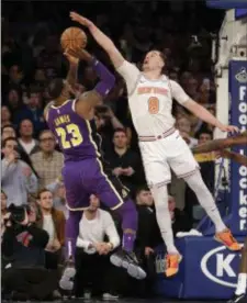  ?? SETH WENIG — THE ASSOCIATED PRESS ?? New York Knicks’ Mario Hezonja (8), right, blocks what could have been the winning shot by Los Angeles Lakers’ LeBron James, left, during the second half of Sunday’s game.