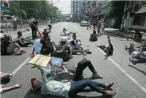  ??  ?? 更多公务员加入罢工仰­光示威者周五躺在街头­堵路，继续抗议。（法新社照片）