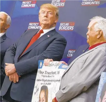  ?? AP ?? President Trump meets people holding posters of people allegedly killed by illegal immigrants. Trump autographe­d photos (below) of the victims.