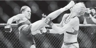  ?? STEVE MARCUS LAS VEGAS SUN ?? Amanda Nunes lands a kick on Holly Holm that knocked her to the mat in the first round of their bantamweig­ht title mixed martial arts bout during UFC 239 in Las Vegas on Saturday. Nunes won in the first round.