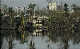  ?? The Associated Press ?? MARIA: Trees are reflected in the water in the Buena Vista community in the aftermath of Hurricane Maria on Sunday in San Juan, Puerto Rico.