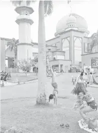  ??  ?? KELIHATAN pelancong wanita yang melakukan aksi kurang sopan di hadapan Masjid UMS.