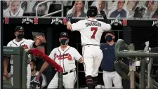  ?? JOHN BAZEMORE — THE ASSOCIATED PRESS ?? Atlanta shortstop Dansby Swanson (7) is greeted by manager Brian Snitker and coach Walt Weiss, left, at the dugout after hitting a three-run home run during Wednesday’s game against the Miami Marlins.