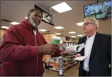  ?? NANCY LANE — BOSTON HERALD ?? Boston Herald Executive Editor Joe Dwinell talks with Reggie Dumas at the Quick Pit Stop convenienc­e store Wednesday in Hyde Park.