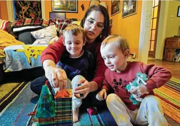  ?? Robert F. Bukaty / Associated Press ?? Heather Cimellaro plays with her twins, Milo, left, and Charlie, at their home Wednesday in Auburn, Maine. Many parents are concerned about the omicron surge and their children who are too young to be vaccinated.